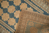 The hand-knotted reverse and low-pile floral front of a distressed Turkish Oushak rug.