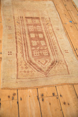 Angled view of a distressed Anatolian runner, highlighting its low pile and geometric medallions.