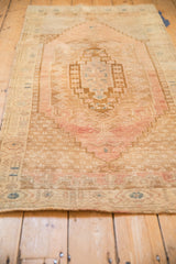 Low angle view along the length of a distressed Oushak rug, showing its soft texture and worn pile.