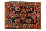Antique Persian Lilihan rug with a floral bouquet medallion and sprawling roses on a deep navy blue field.