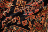 The soft, hand-knotted pile of an antique Lilihan rug, showing its rich navy and brick red colors.