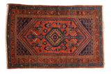 Vintage Kurdish Hamadan rug with a sharp serrated hexagonal medallion in red, navy blue, and brown tones.
