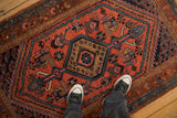 Sharp serrated hexagonal medallion with cypress finials on a vintage red Kurdish rug.