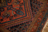 Corner spandrel of a vintage Hamadan rug with serrated mahi-mahi designs in red and navy.