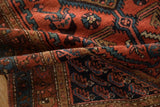 The pliable hand-knotted pile of a vintage Hamadan rug with madder red and navy blue details.
