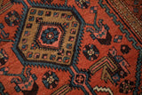 Low-pile wool texture of a vintage Hamadan rug's serrated medallion and mahi-mahi motifs.