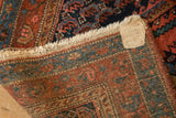 Corner detail of a vintage Kurdish Hamadan rug, showing the hand-knotted reverse and tag.