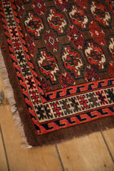 Corner detail of an antique Turkmen rug showing the reciprocating wave border and low pile.