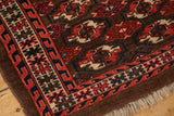 The reciprocating wave border and even wear on the corner of an antique Turkmen wool rug.
