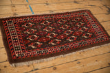 A full perspective view of an antique Turkmen rug with geometric guls and a reciprocating wave border.