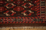 Tattered ivory fringe below a geometric wave border on an antique Turkmen rug.