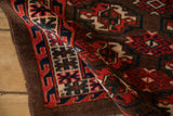 Even wear and intricate wave border of an antique hand-knotted Turkmen rug.