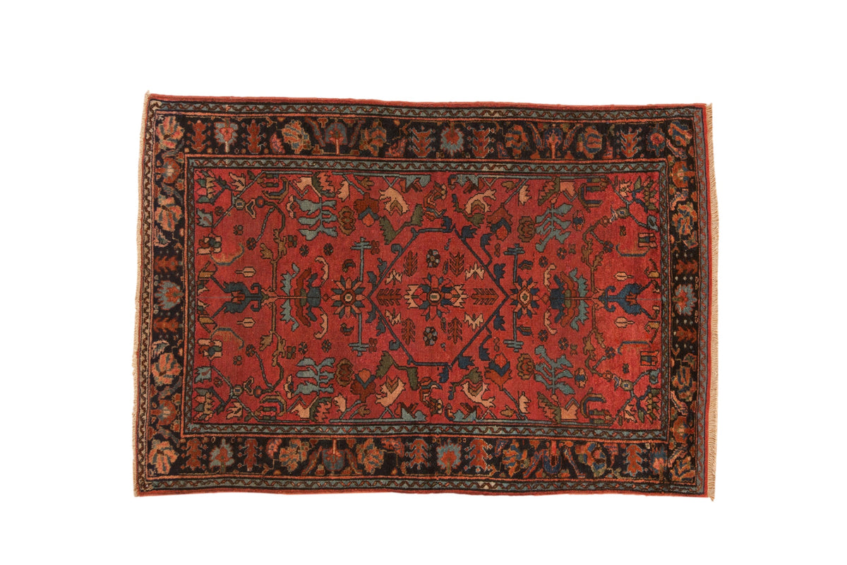 Antique Lilihan rug with a hexagonal shadow medallion over a raspberry red field and a dark floral border.