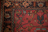 Corner of an antique Lilihan rug showing its floral border with stylized serrated mahi-mahi leaves.