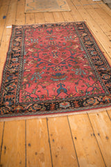 A perspective view of the antique Lilihan rug's traditional floral design and rich raspberry red color.