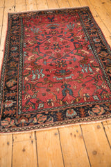 Angled view of an antique Lilihan rug's hexagonal medallion and raspberry red floral field.