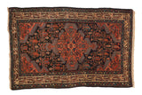 Vintage Persian Tajabad rug with a center medallion, navy field, and boteh vinery in blush and blue.