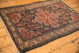 Vintage Persian Tajabad rug from an angle, highlighting its geometric boteh and medallion design.