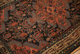Close-up showing the low pile texture and finned leaf and boteh designs of a vintage Persian rug.