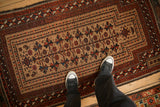 A view of the mostly even wear and low, hand-knotted pile of an antique Belouch rug.