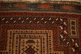 The complex geometric floral gul and serpent borders on the corner of an antique Belouch rug.