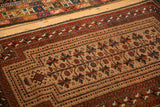 Angled view of the antique Belouch rug's geometric borders and the authentic wear on its selvage.