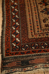 Corner detail of an antique Belouch rug showing geometric serpent borders and authentic wear.