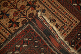 Antique Belouch rug corner detail showing the serpent design border and hand-knotted back.