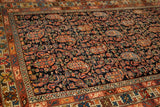 Angled view of an antique Hamadan rug showing the intricate boteh pattern and colorful stylized borders.