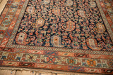 Corner detail of an antique Hamadan showing the crab-stylized border and navy blue boteh field.