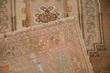 A vintage Oushak rug's corner turned back, revealing the hand-knotted weave and side cord.