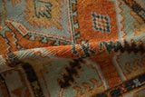 A soft fold in the distressed Oushak runner highlights the low, hand-knotted pile in burnt orange and jade green.