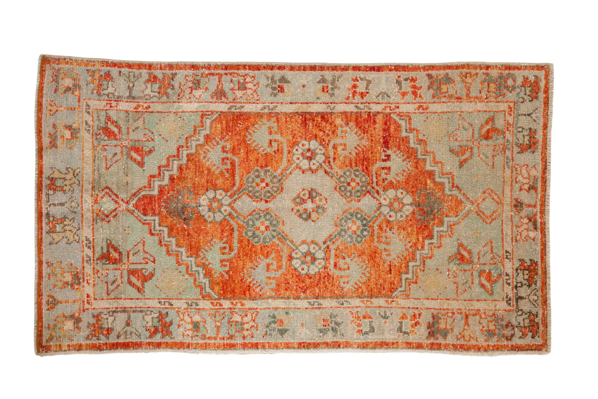 Vintage distressed Oushak rug with a stepped brick red medallion on a jade green field.