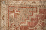 Distressed vintage Oushak runner pile, showing plum pinwheel motif with ivory and subtle blue.