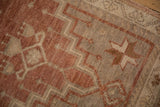 Distressed Oushak rug's low pile, showing stepped geometric patterns in dusty plum and antique ivory.