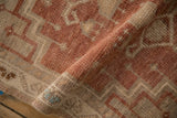 Vintage distressed Oushak rug pile texture with plum, ivory, and blue geometric pattern.