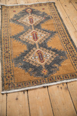 Angled side view of a distressed Oushak runner's bronze and charcoal geometric pile.