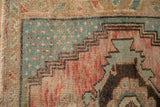 Distressed vintage Oushak rug close-up, seeded florals on abrashed denim blue field, stepped contour.