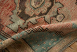 Distressed vintage Oushak rug fold showing textured pile, seeded blue, and cantaloupe motifs.