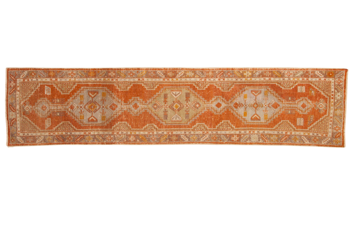 Distressed vintage Oushak runner with interconnected hexagonal medallions in tangerine orange, slate blue, and sand.