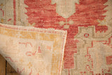 Corner of a distressed Turkish rug showing the worn pile and hand-knotted foundation.