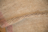 Distressed beige Tulu rug's short, soft wool pile texture and intact side cord.