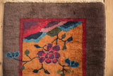 Plush pile corner of a Nichols Art Deco rug with cochineal red and mauve mountain motifs.