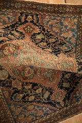 A soft fold revealing the supple hand-knotted weave of an antique Persian Sarouk rug.