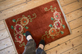 A vintage copper Art Deco rug with floral sprays shown to scale underfoot.