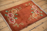 Angled perspective of an Art Deco rug's reciprocal floral design on a textured copper field.