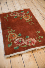 Angled view of the vintage Art Deco rug highlighting the floral design on its copper field.