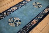 View along the vintage Peking runner's sky blue field, showing roundel medallions and age-related patina.