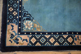 Corner detail of a vintage Peking rug with a pale rose blossom and pearl design borders.