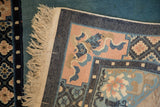 Folded corner of a vintage Peking rug showing its hand-knotted foundation and side cord selvage.